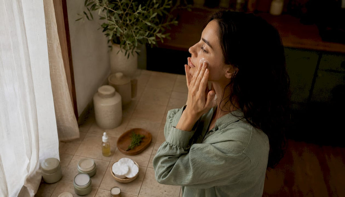 Woman applying serum in bathroom
