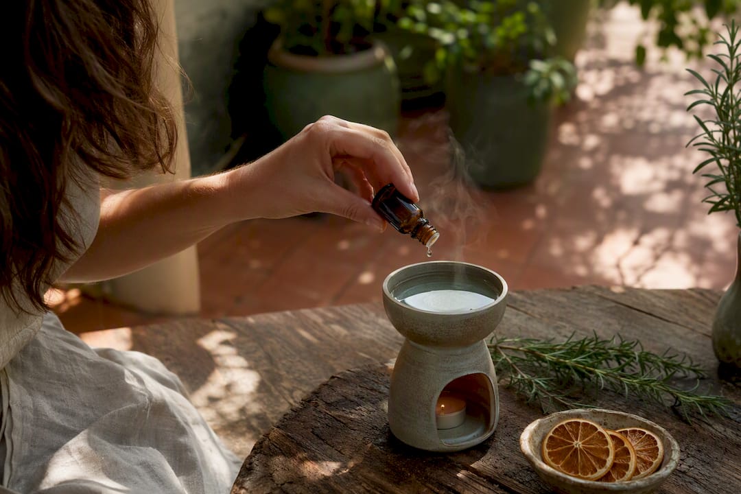 Hand pouring essential oil into diffuser