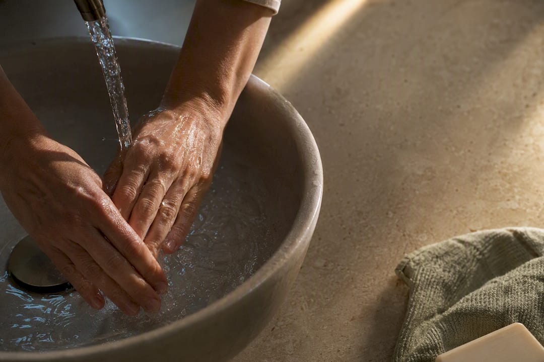 Hands washing under cool running water