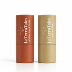 Two LaTerraTales ArnicaCare lip balm tubes standing upright on a white background, one in terracotta orange and one in light tan 
