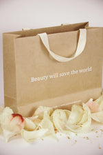 LaTerraTales bag with text 'Beauty will save the world' and flowers on a white background