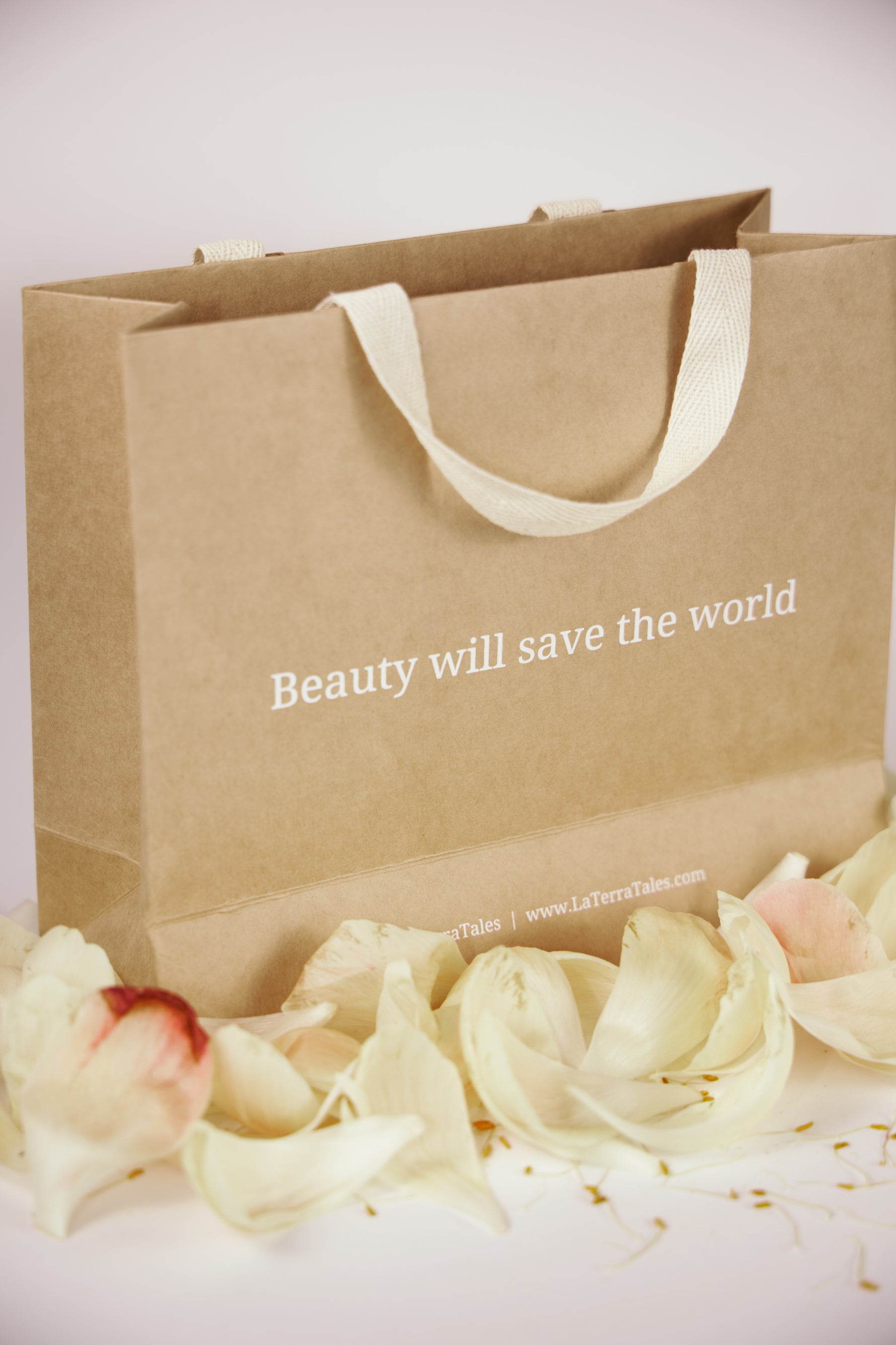 LaTerraTales bag with text 'Beauty will save the world' and flowers on a white background
