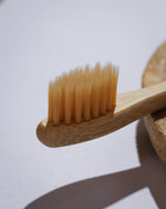 Close-up of a soft wooden toothbrush LaTerraTales with bristles on a light background
